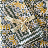 Green and white striped fabric with a yellow ribbon on a floral-patterned background
